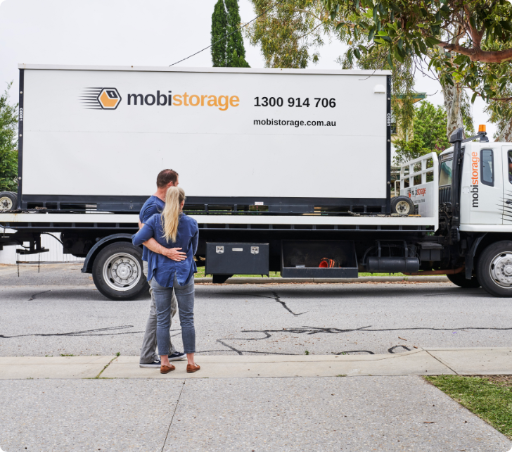 12-1056-0860 man and women observing mobile storage container on truck