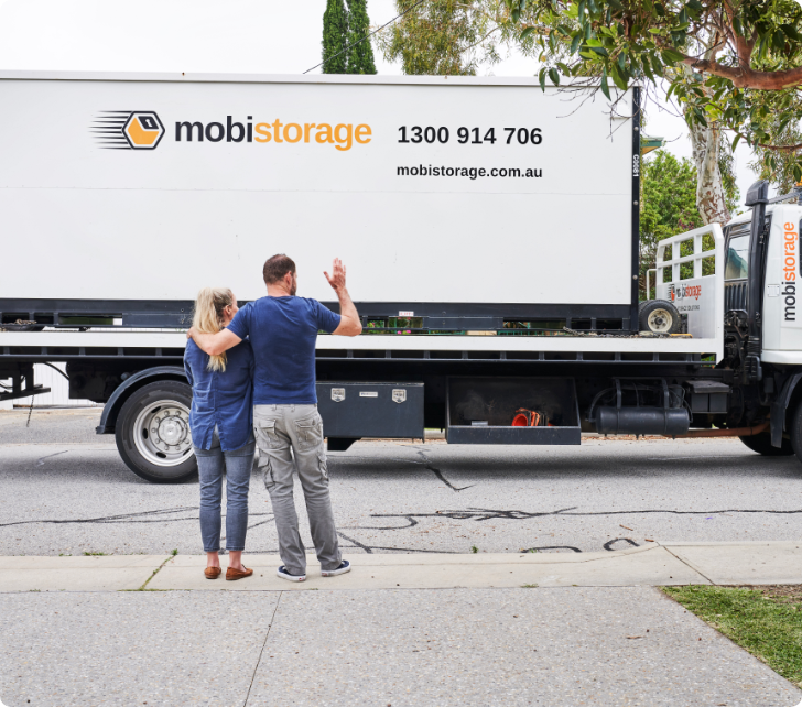 9-1056-0912 women and man waving to mobistorage truck driver
