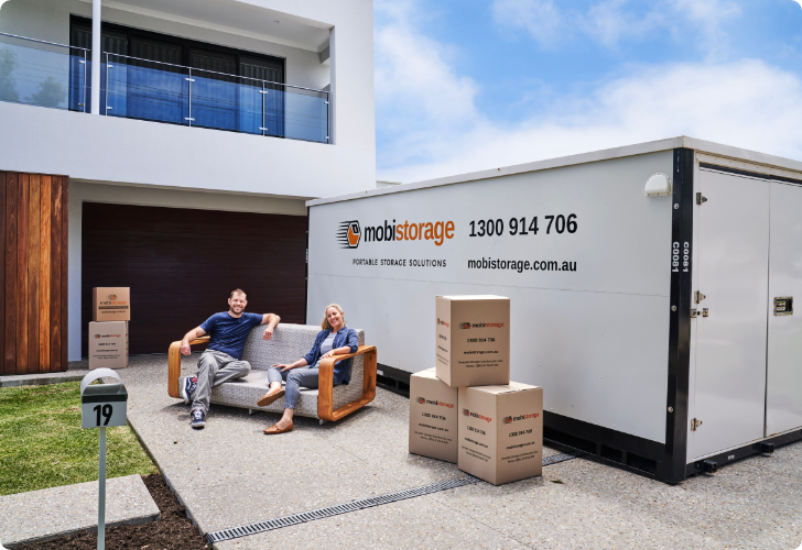MOBI_Couple_Container_Seated_Outside_0504 A couple sitting on their couch beside a mobistorage container