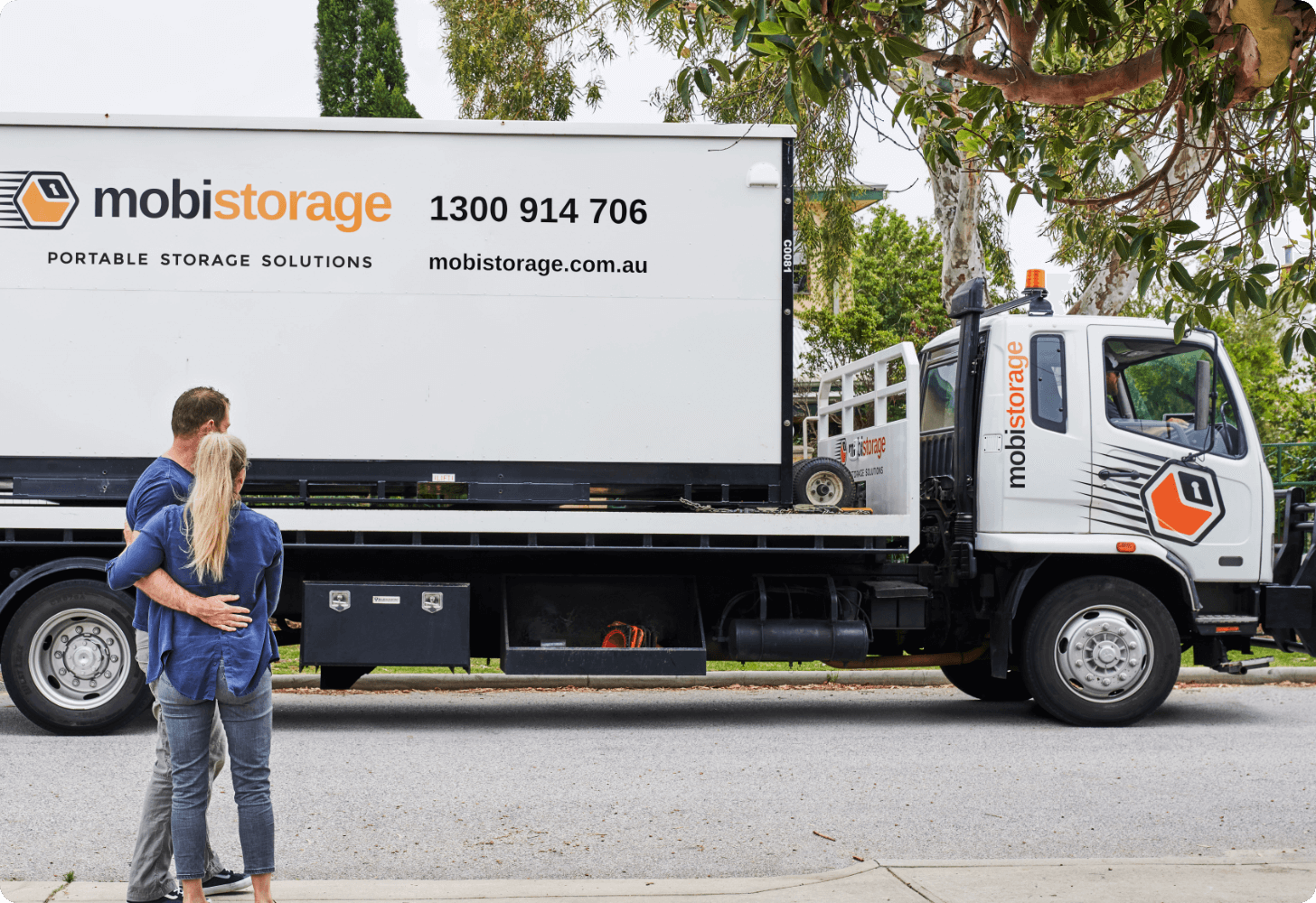 man and women standing in front of mobile storage container